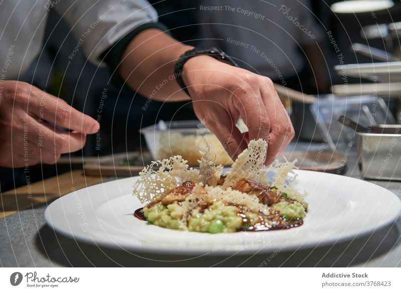 Crop Koch Kochen Risotto in der Küche Reis Garnierung Restaurant Bohnenkraut Chip köstlich Knusprig kulinarisch Küchenchef Teller frisch Lebensmittel Mahlzeit