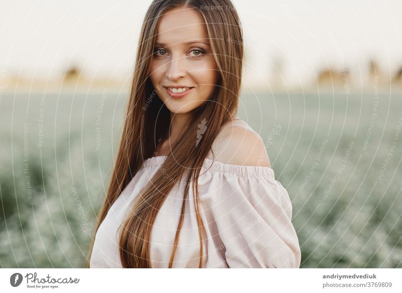 Schöne Frau genießt Feld, glückliche junge Dame und frühlingsgrüne Natur, Harmoniekonzept. Portrait eines schönen Mädchens in einem Blumenfeld. selektiver Fokus