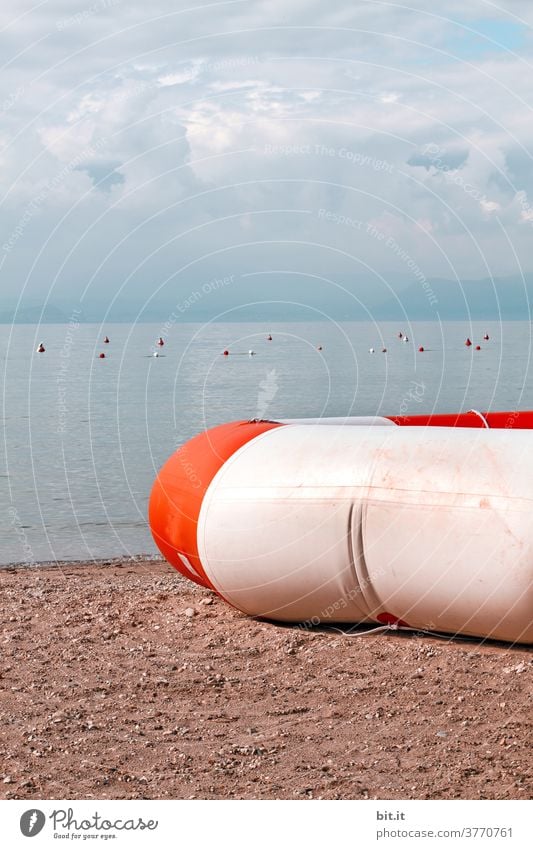 großer Rettungsring, liegt unter bewölktem Himmel, am Seeufer, auf dem Sandstrand. retten Retter Rettungsgeräte Reifen Schwimmen & Baden Schwimmhilfe Badestelle