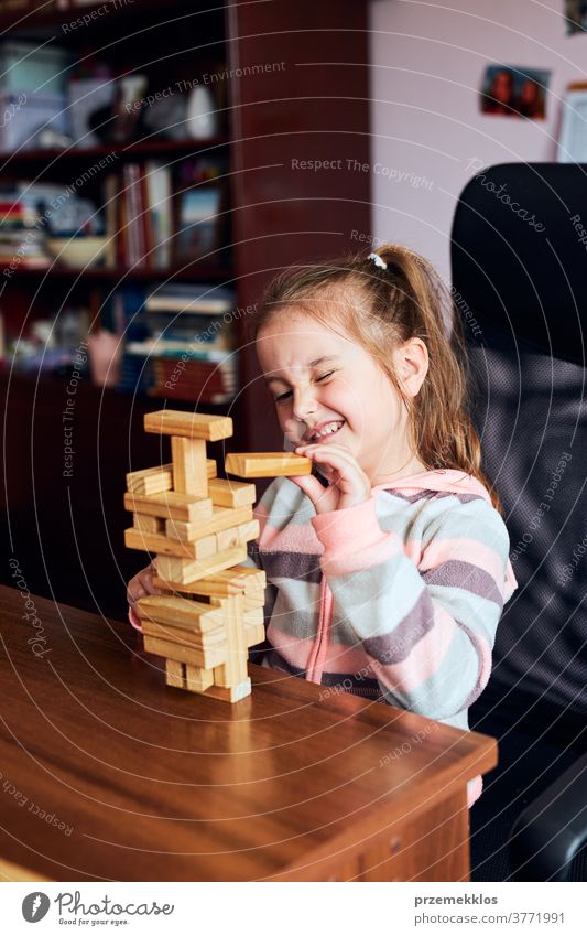 Kleines Mädchen im Vorschulalter spielt mit Holzklötzen Spielzeug, das ein Haus baut Aktivität Klotz Blöcke Baustein bauen Kind Kindheit Konzept Konstruktion