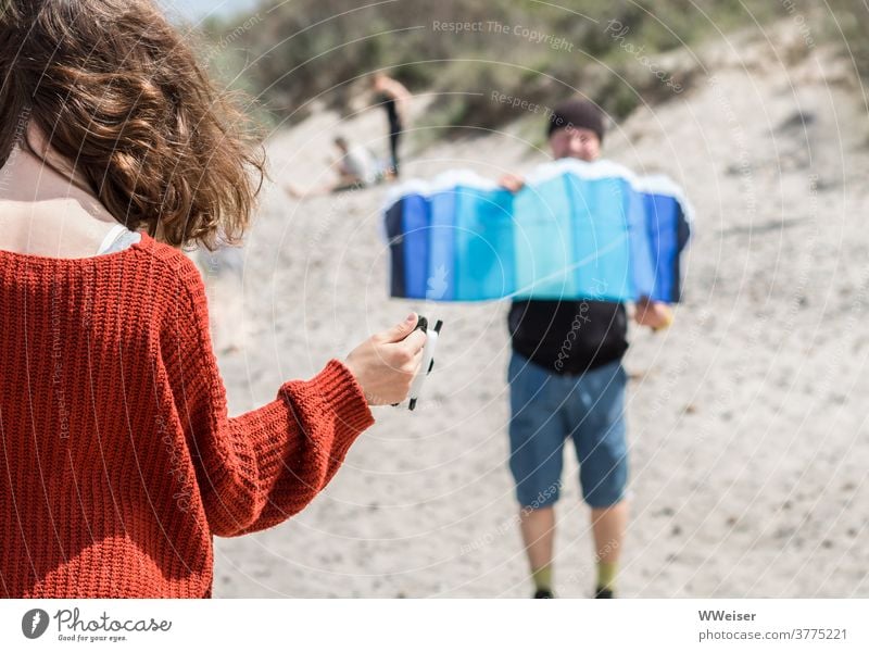 Drachen steigen lassen erfordert eine gute Abstimmung zwischen Vater und Tochter Wind Strand Sonne Flugmatte Lenkmatte Lenkdrachen Mädchen Kind Locken Haare