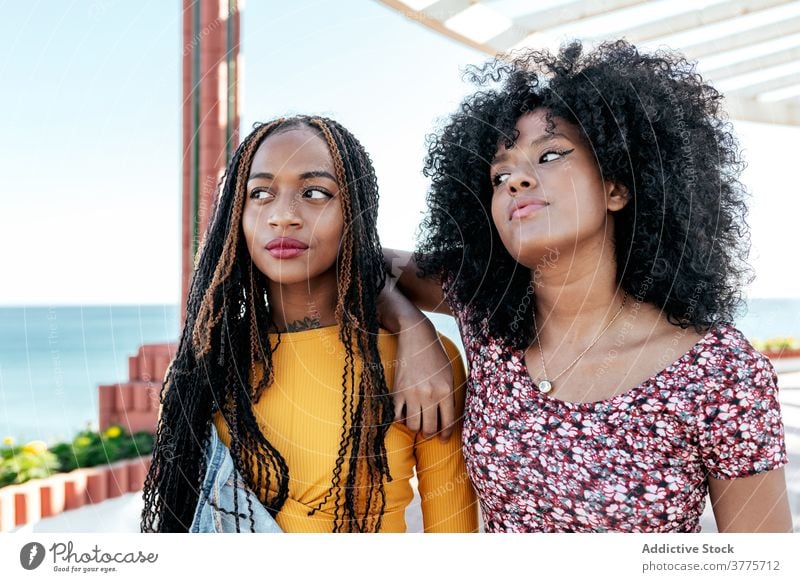 Nachdenkliche ethnische Frauen an der Strandpromenade ernst bester Freund Umarmung Freundschaft besinnlich Zusammensein nachdenklich Sommer Stauanlage schwarz