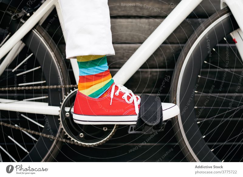 Crop Person in bunten Socken auf dem Fahrrad Streifen Kniestrümpfe farbenfroh Regenbogen kreativ Spaß Fahrzeug modern Großstadt Straße urban Stil trendy Verkehr