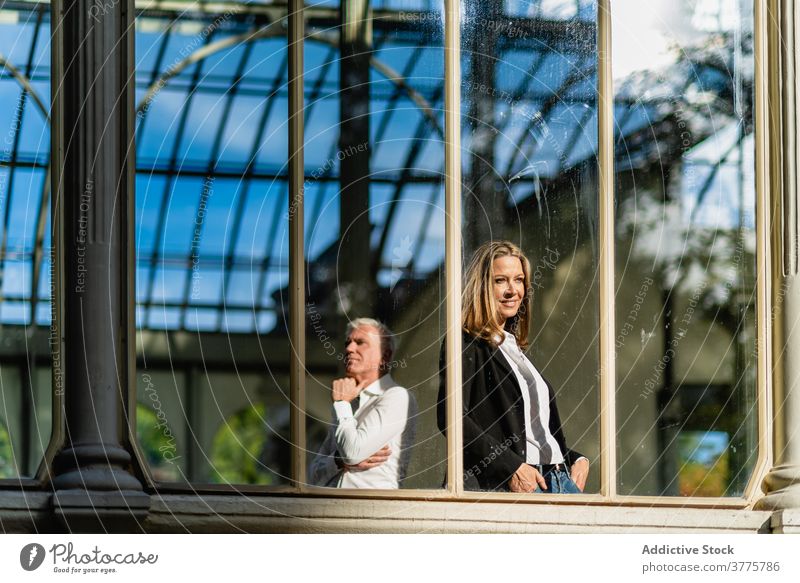 Seriöses Coupé im Glasbau zusammen Paar Lebensmitte Gebäude Zusammensein nachdenklich nachdenken historisch schlendern Fenster Außenseite urban