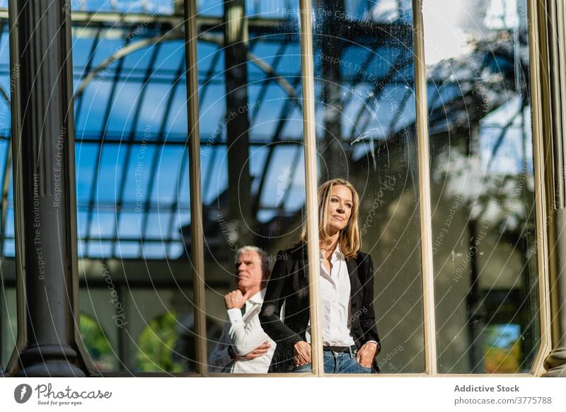 Seriöses Coupé im Glasbau zusammen Paar Lebensmitte Gebäude Zusammensein nachdenklich nachdenken historisch schlendern Fenster Außenseite urban