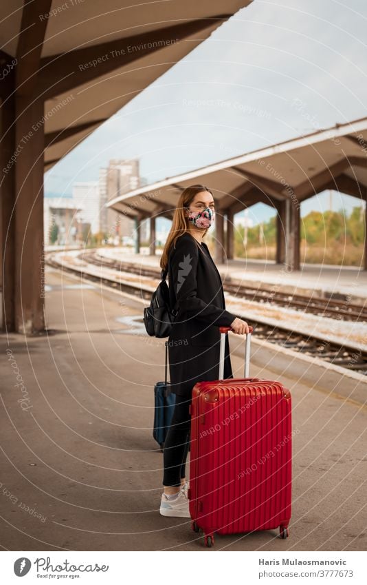 Frau mit Maske und Reisetasche wartet am öffentlichen Bahnhof Erwachsener attraktiv Tasche Gepäck schön Business Kaukasier Großstadt Coronavirus covid-19