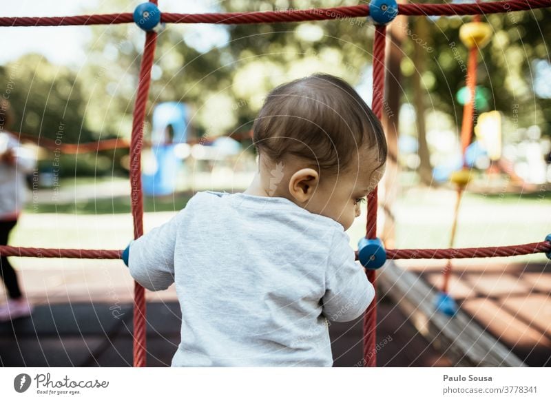 Rückansicht eines auf dem Spielplatz spielenden Kindes Kindergarten Kleinkind Kindheit Kinderspiel Kindererziehung 1-3 Jahre Mensch Freizeit & Hobby Farbfoto