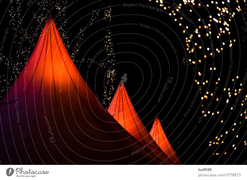 rote Zeltdächer mit Lichterketten auf einem Weihnachtsmarkt leuchtende Farben rot leuchtend Weihnachten Weihnachtsbeleuchtung Weihnachtsbaum Unschärfe