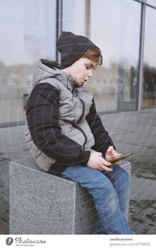 7-jähriger Junge spielt im Winter mit Smartphone im Freien Kind Handy Telefon Technik & Technologie spielen Spielen Menschen jung Internet Kindheit Lifestyle