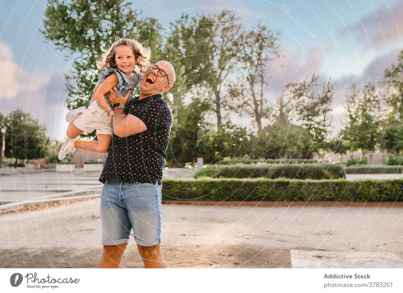 Positive Mann spielt mit niedlichen Mädchen auf der Straße Vater Tochter werfen Spaß haben spielen Spiel Vaterschaft Liebe Großstadt Zusammensein Wochenende