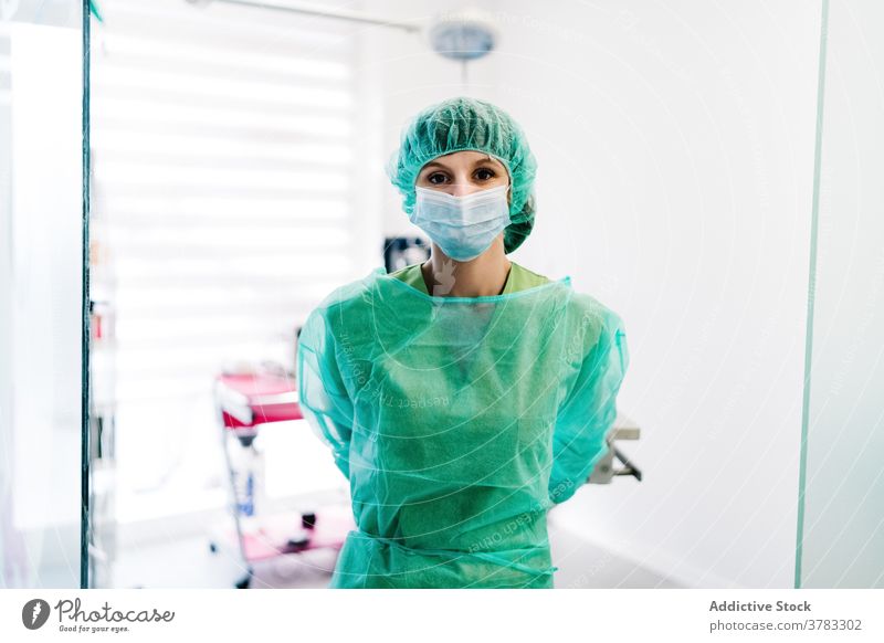 Weiblicher Arzt in der Tierklinik schaut in die Kamera Tierarzt Veterinär Operationssaal Frau vorbereiten angezogen Handschuh Uniform Klinik Mundschutz Chirurg