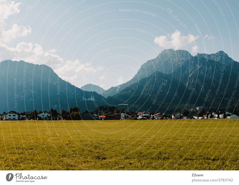 Bergkulisse mit Schloss Neuschwanstein berge alpen allgäu bayern füssen Schloß Neuschwanstein neuschwanstein dorf himmel wiese grün sommer sonne blau panorama