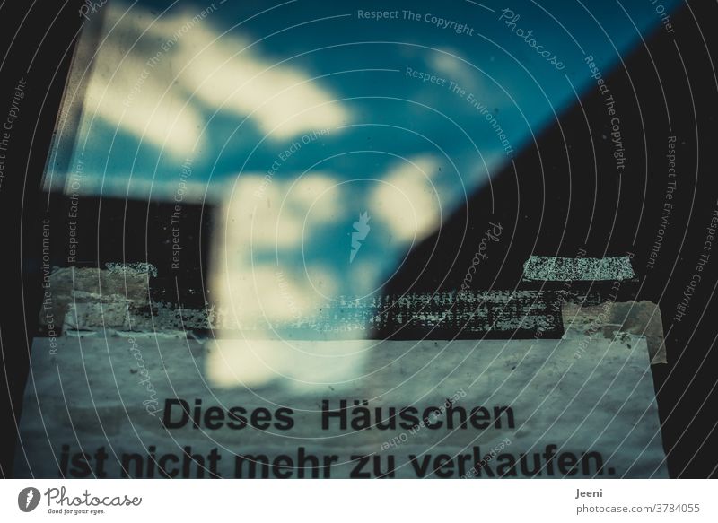 Zettel im Fenster des alten Hauses mit der Aufschrift "Dieses Häuschen ist nicht mehr zu verkaufen" Fensterscheibe Spiegelung Hinweis Reflexion Himmel blau