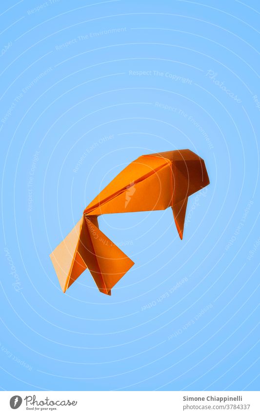 Origami orange-goldener Fisch auf hellblauem Hintergrund Origami-Papier Goldener Fisch Koi Koi-Karpfen hell-blau hellblauer Hintergrund Tier Farbfoto