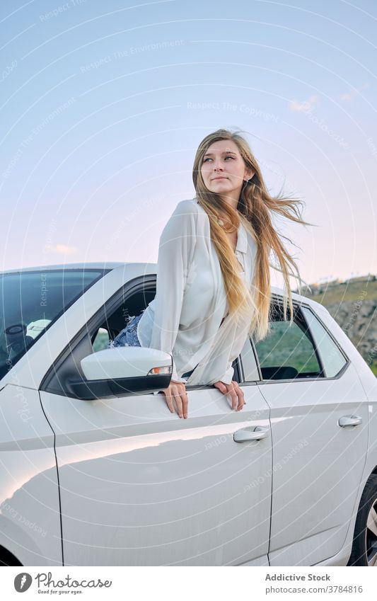 Begeisterte weibliche Reisende aus dem Autofenster PKW Fenster Frau genießen sorgenfrei reisen Reisender Fernweh Automobil Sommer Natur Urlaub Abend ruhen