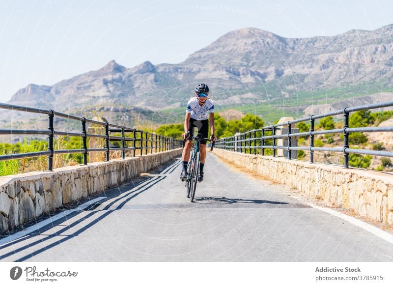 Radfahrer auf der Landstraße im Hochland Fahrrad Mitfahrgelegenheit Straße Berge u. Gebirge aktiv Sport Route Training Natur Frau Lifestyle Aktivität Gesundheit