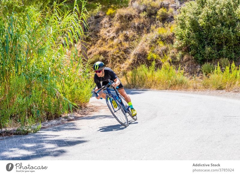 Sportlicher Radfahrer fährt Fahrrad auf Bergstraße Mitfahrgelegenheit Berge u. Gebirge Straße bergab Training aktiv Lifestyle Ausdauer Aktivität Gesundheit