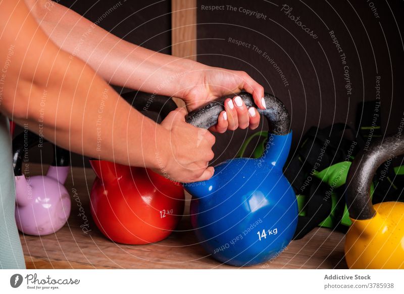 Crop Frau während des Trainings in der Turnhalle mit Kettlebells Sportlerin Fitnessstudio stark schwer Gerät Metall Übung muskulös Athlet passen Gesundheit