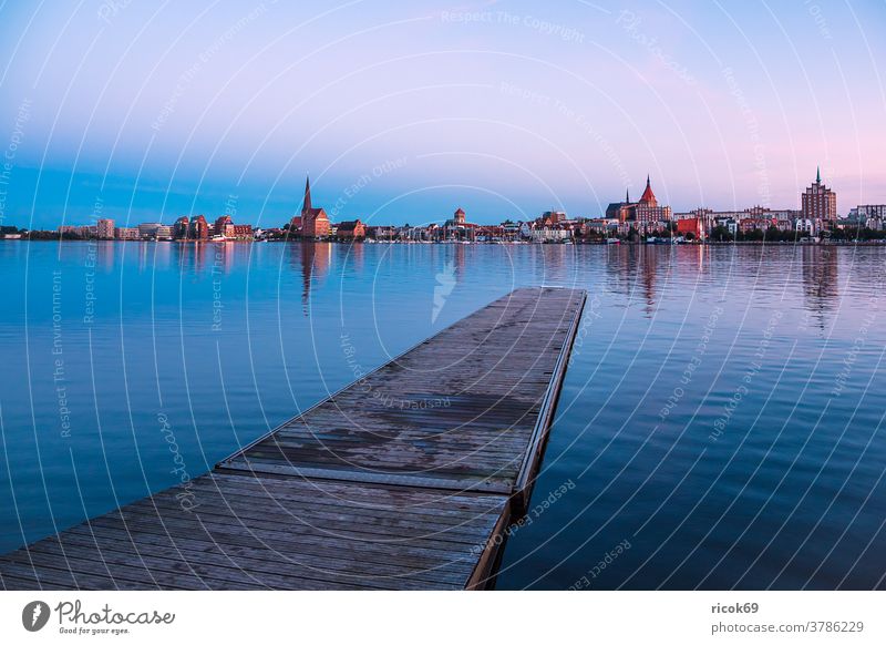 Blick über die Warnow auf die Hansestadt Rostock zur Blauen Stunde Fluss Stadthafen Mecklenburg-Vorpommern Steg Anlegestelle Holzsteg Tourismus Architektur