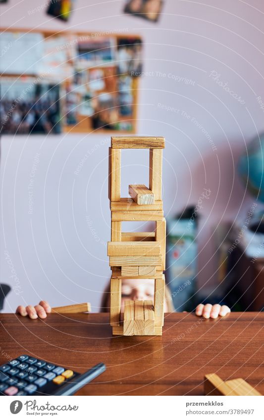 Kleines Mädchen im Vorschulalter spielt mit Holzklötzen Spielzeug, das ein Haus baut Aktivität Klotz Blöcke Baustein bauen Kind Kindheit Konzept Konstruktion