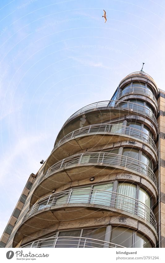 The Tower and the Seagull. Balkone und Fenster eines Hauses an der Strandpromenade von Zeebrugge Fassade Metall Glas Stein See Möwe Nordsee Meer Hotel Himmel