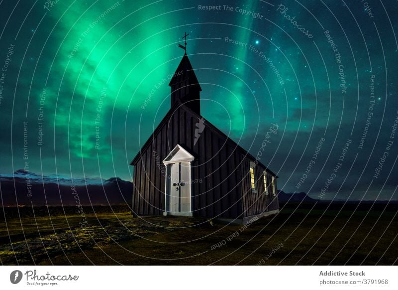 Kleine Kirche in der Nacht gegen den Himmel mit Polarlicht Nordlicht Aurora Erscheinung Gebäude nördlich Licht Stern Island Landschaft malerisch Wiese hölzern