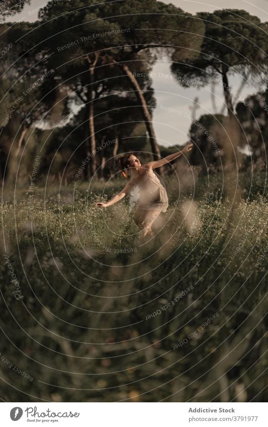 Schlanke Ballerina tanzt im Park bei Sonnenuntergang Balletttänzer Tänzer Anmut Gleichgewicht auf Zehenspitzen Barfuß Wiese ruhig Frau Island ausführen