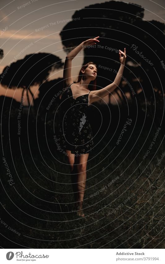 Anmutige Frau tanzt im dunklen Park Balletttänzer Ballerina Tänzer dunkel Wiese Choreographie beweglich Talent Island Kleid Natur elegant Gleichgewicht Künstler