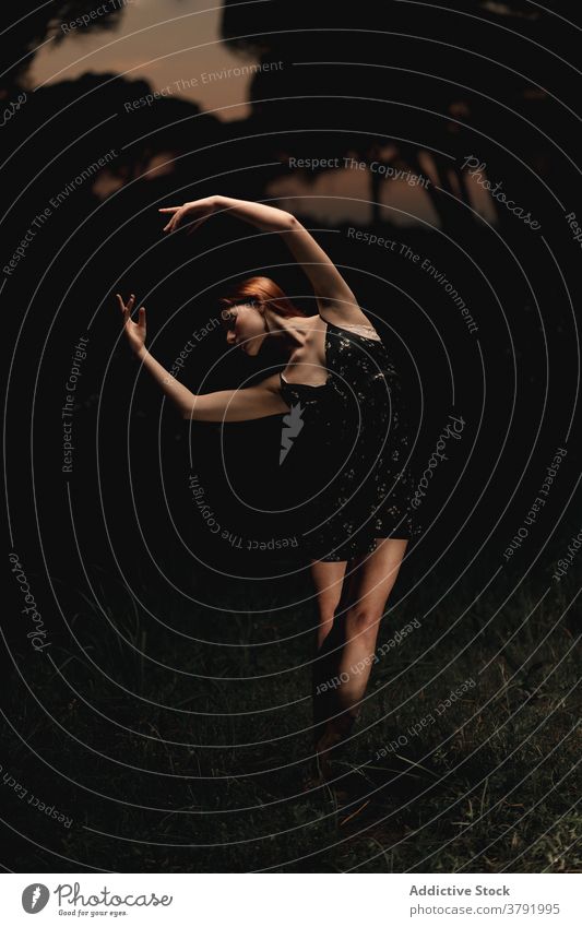 Anmutige Frau tanzt im dunklen Park Balletttänzer Ballerina Tänzer dunkel Wiese Choreographie beweglich Talent Island Kleid Natur elegant Gleichgewicht Künstler