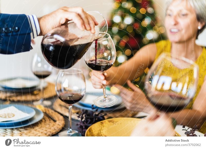 Mann serviert Wein an Heiligabend Weihnachten jubelt Servieren Weinglas Zuprosten gesichtslos feiern sich[Akk] sammeln Beschnittansicht Freund heiter festlich