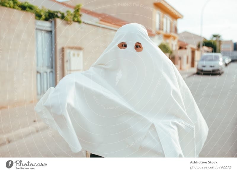 Gespenstisches Kind im Geisterkostüm in der Stadt Tracht Halloween Feiertag Spaß haben spukhaft erschrecken Straße Tradition Kindheit Saison Herbst fallen