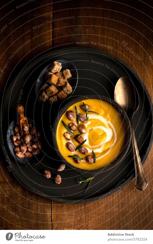 Appetitliche Kürbiscremesuppe in Schale auf dem Tisch Sahne Suppe Speise dienen Mittagessen Brot Crouton gesunde Ernährung Vegetarier hölzern Lebensmittel