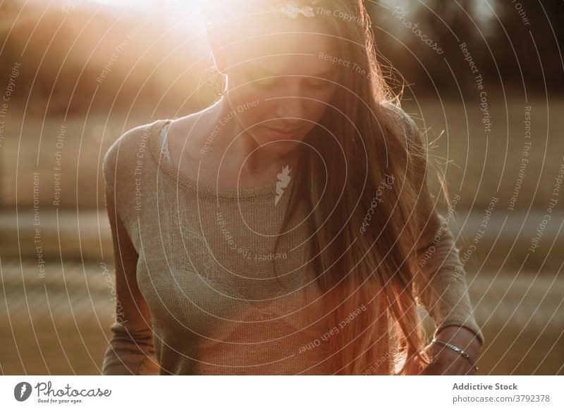 Crop ruhig attraktive Frau in der Natur in der Abendsonne stehen charmant Gelassenheit friedlich Windstille traumhaft emotionslos Park Sonnenstrahlen sanft