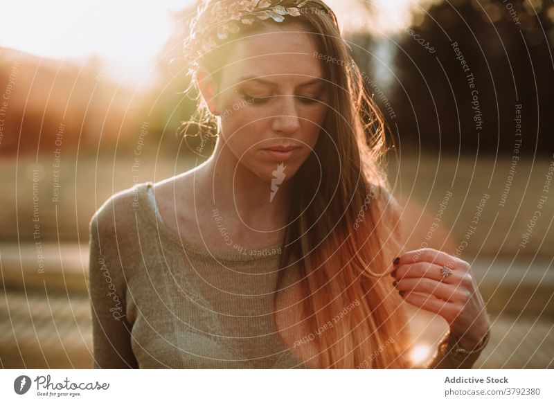 Crop ruhig attraktive Frau in der Natur in der Abendsonne stehen charmant Gelassenheit friedlich Windstille traumhaft emotionslos Park Sonnenstrahlen sanft