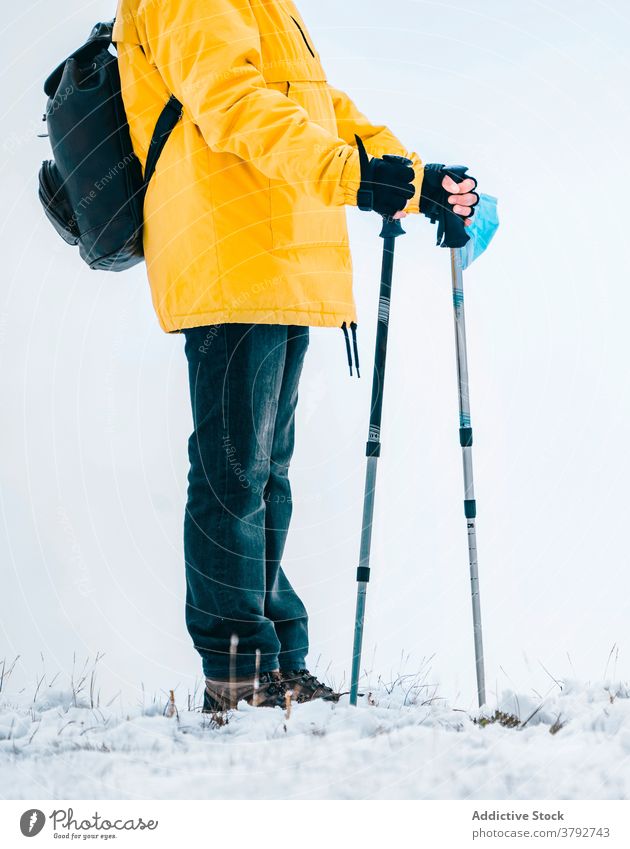 Wanderer mit Schutzmaske auf verschneitem Gelände stehend Trekking Reisender Mundschutz Coronavirus aktiv Schnee Berge u. Gebirge Rucksack Abenteuer COVID19