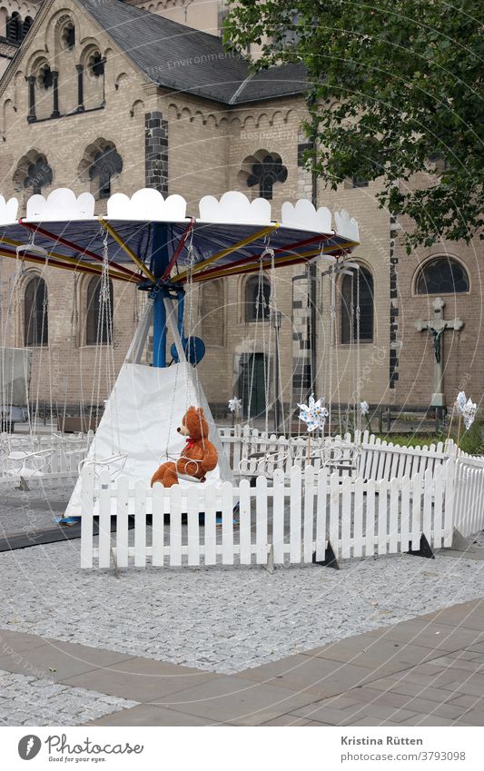 teddybär sitzt im ansonsten leeren kinderkettenkarussell kinderkarussell einsam alleine platzhalter niemand warten jahrmarkt rummel kirmes plüschtier