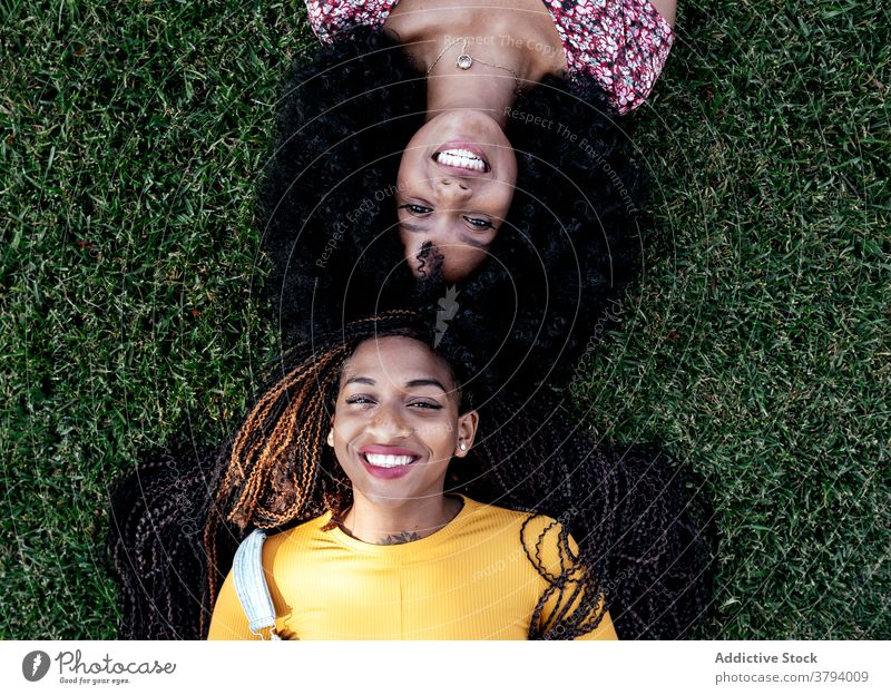 Inhalt schwarze Frauen auf Gras im Park Freundschaft Lügen Freundin Zusammensein Lächeln Sommer ethnisch Afroamerikaner Wochenende sorgenfrei Freude positiv