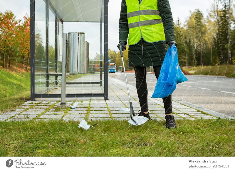 Coronavirus-Müll. Freiwillige, die gebrauchte medizinische Einwegmasken und -handschuhe in der Nähe der Bushaltestelle und entlang der Autobahn sammeln. Das Problem der Umweltverschmutzung während einer Pandemie COVID-19