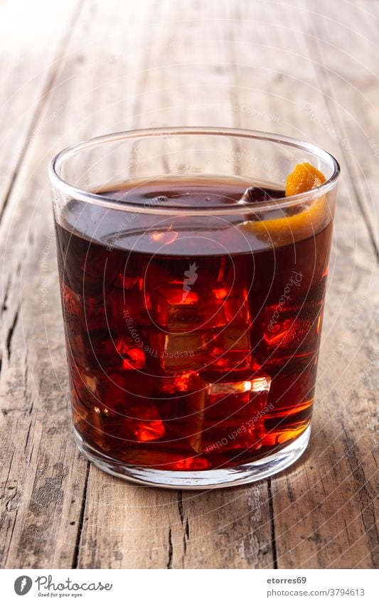 Boulevardier-Cocktail und Orangenschale alkoholisch Getränk boulevardier campari kalt trinken Eleganz frisch Frucht Glas Eis mischen orange rot rustikal