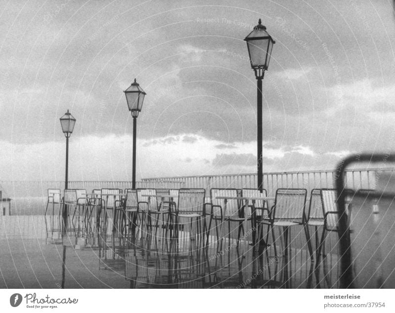 Düsterstrand 4 Küste Terrasse Laterne Stuhl grau Wolken nass Natur Landschaft Regen Wasser Schwarzweißfoto