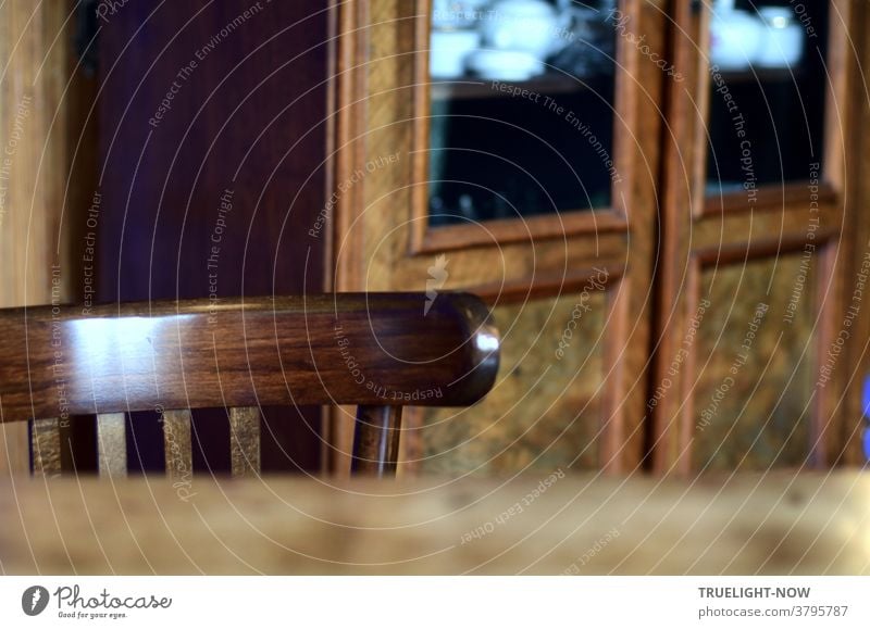 Das museal gepflegt polierte Holz von Tisch, Stuhl (Lehne) und Schrank ist nicht wirklich gemütlich, spiegelt aber irgendwie geheimnisvoll das durch ein nicht sichtbares Fenster einfallende Tageslicht