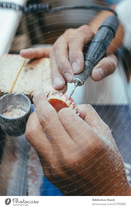 Crop Mann mit Maschine Polieren künstliche Kiefer Zahnersatz dental Techniker Zähne polnisch Prothesen männlich Arbeit Labor professionell Werkzeug Beruf Gerät