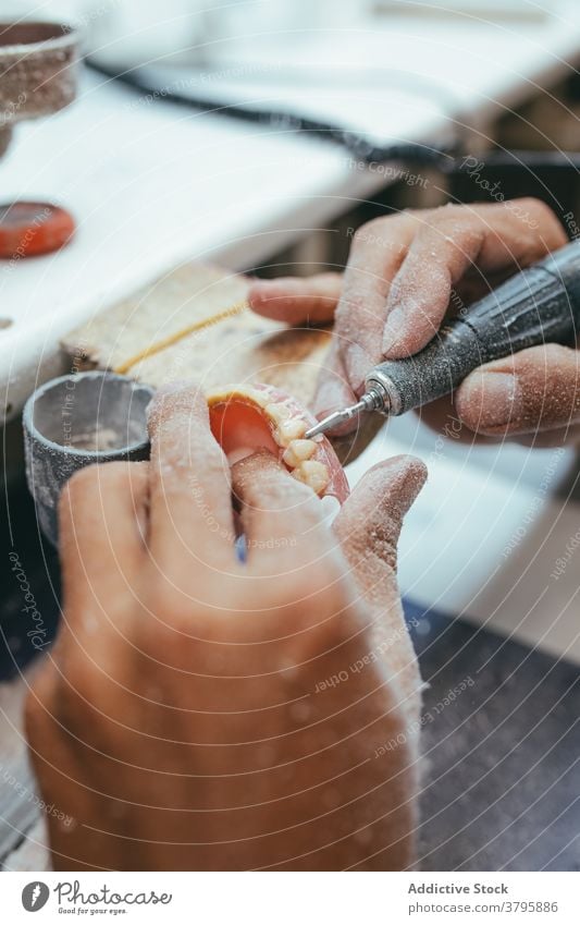 Crop Mann mit Maschine Polieren künstliche Kiefer Zahnersatz dental Techniker Zähne polnisch Prothesen männlich Arbeit Labor professionell Werkzeug Beruf Gerät