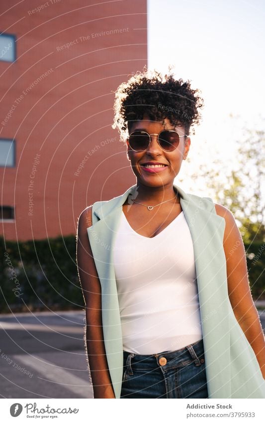 Glückliche ethnische Frau in trendigem Outfit und Sonnenbrille Stil trendy Mode urban Sommer Afro-Look Lächeln heiter jung Afroamerikaner schwarz positiv lässig