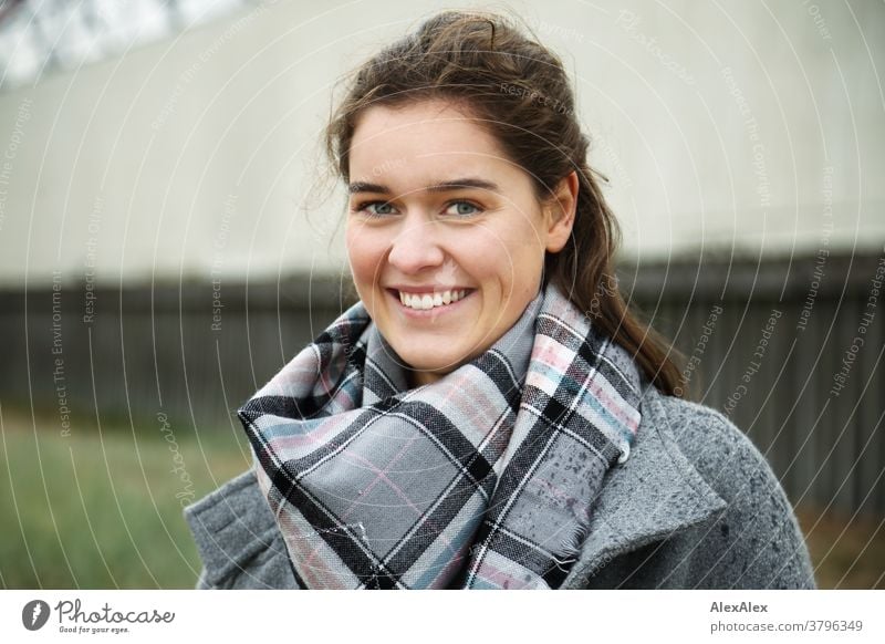 Nahes Portrait einer jungen Frau mit Grübchen, die draußen vor einem Gebäude steht junge Frau 18-25 Jahre Lächeln Freude warmherzig schön charmant schlank