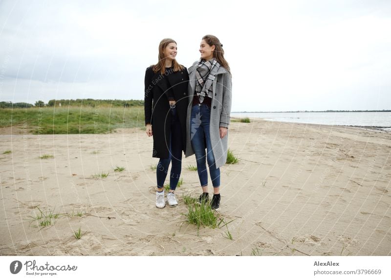 Portrait zwei jungen Frauen -  Freundinnen - am Elbstrand junge Frau 18-25 Jahre warmherzig schön charmant schlank brünett lange Haare frisch groß smart