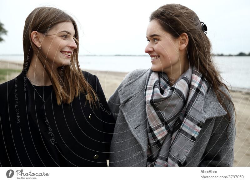 Portrait zwei junger Frauen -  Freundinnen - am Elbstrand junge Frau 18-25 Jahre warmherzig schön charmant schlank brünett lange Haare frisch groß smart