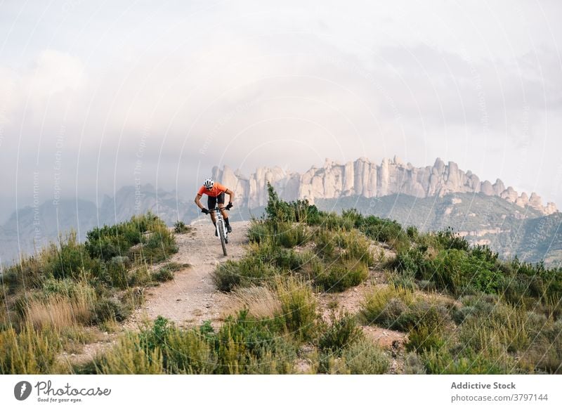 Aktiver Mann mit Fahrrad in hügeligem Terrain Radfahrer Berge u. Gebirge Hügel aktiv Sport Mitfahrgelegenheit Natur männlich Schutzhelm Abenteuer Verkehr reisen