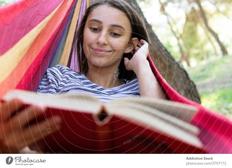 Entspannte Frau liest Buch in Hängematte lesen Etage genießen Sommer Lügen Park Literatur interessant friedlich Roman ruhig lässig Hobby Natur Erholung