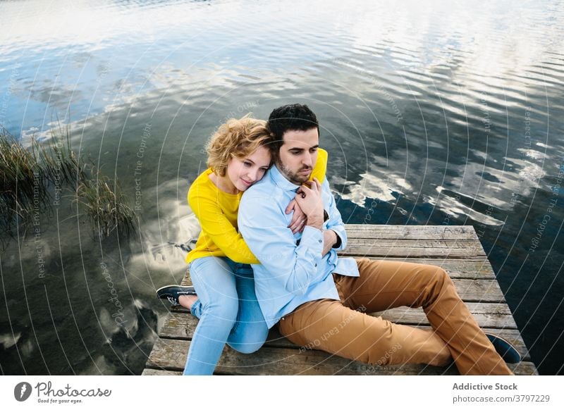 Zufriedenes Paar umarmt auf Pier im Sommer hölzern See Umarmen Liebe Angebot Partnerschaft Teich sorgenfrei Windstille Freundin sanft romantisch Zuneigung